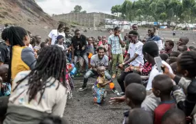 A group of people dancing around a child. 